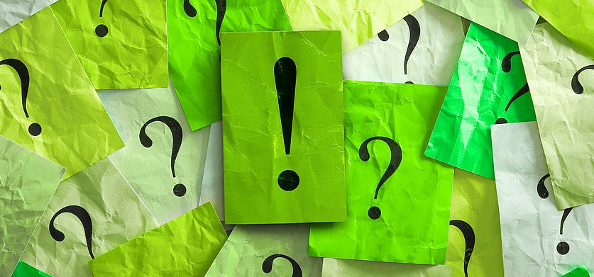 Fragezeichen und Ausrufezeichen auf gr&uuml;nen Post-its.