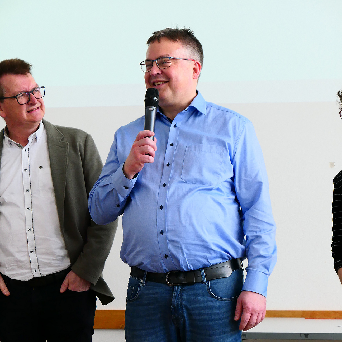 Ein Dozent h&auml;lt ein Mikrofon in der Hand.