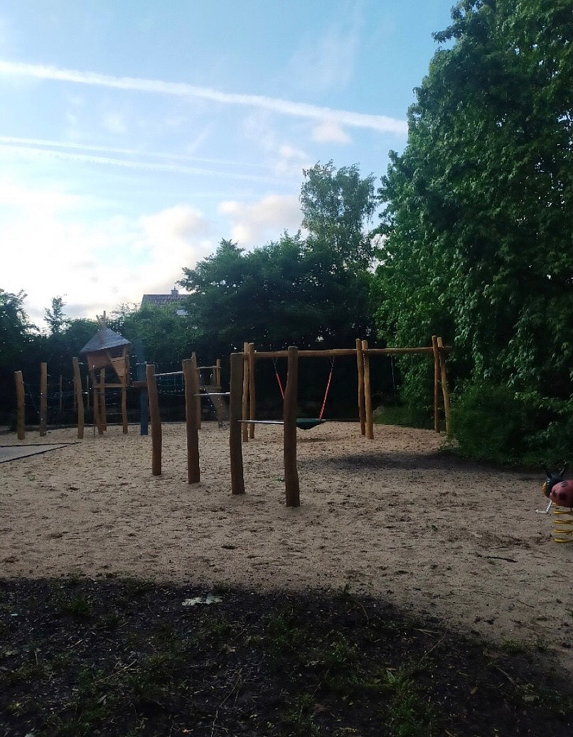 Spielplatz mit Spielger&auml;ten gebaut aus Holzbalken (Spielturm, Reck, Schaukeln)