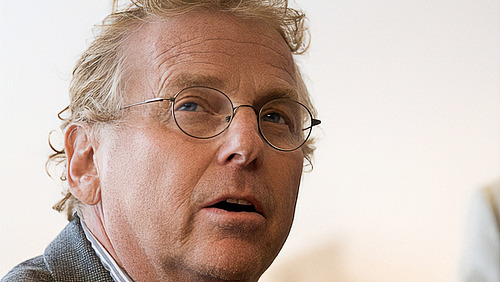 Der Kopf eines Mannes blickt in die Kamera vor wei&szlig;em Hintergrund.