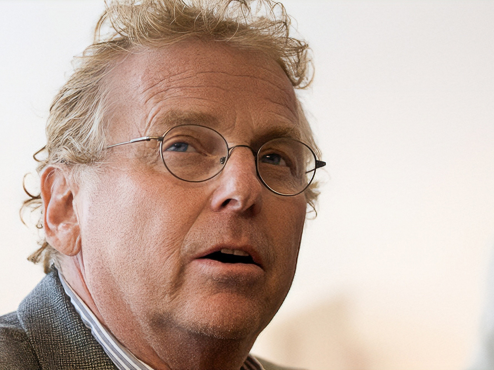 Der Kopf eines Mannes blickt in die Kamera vor wei&szlig;em Hintergrund.