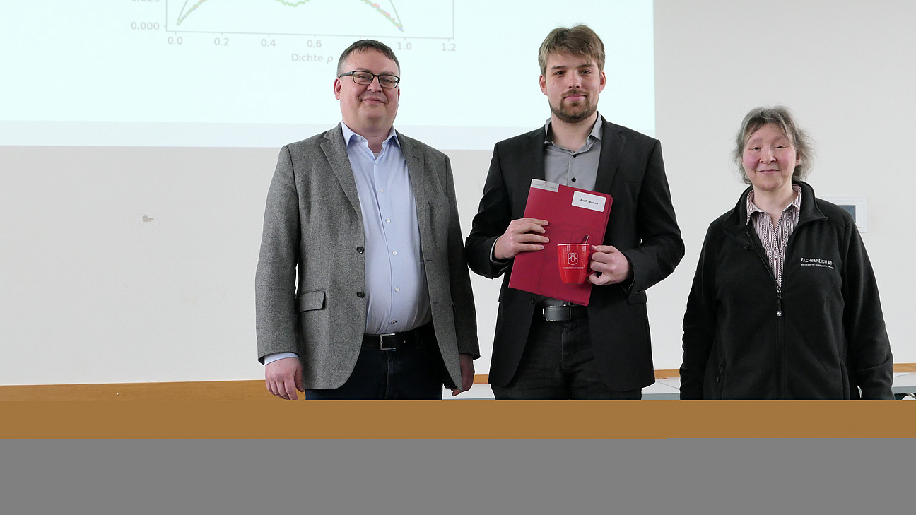 A graduate stands between the dean and the dean of studies.