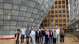 A group of students stand in the foyer of the main building of the European Council in Brussels.
