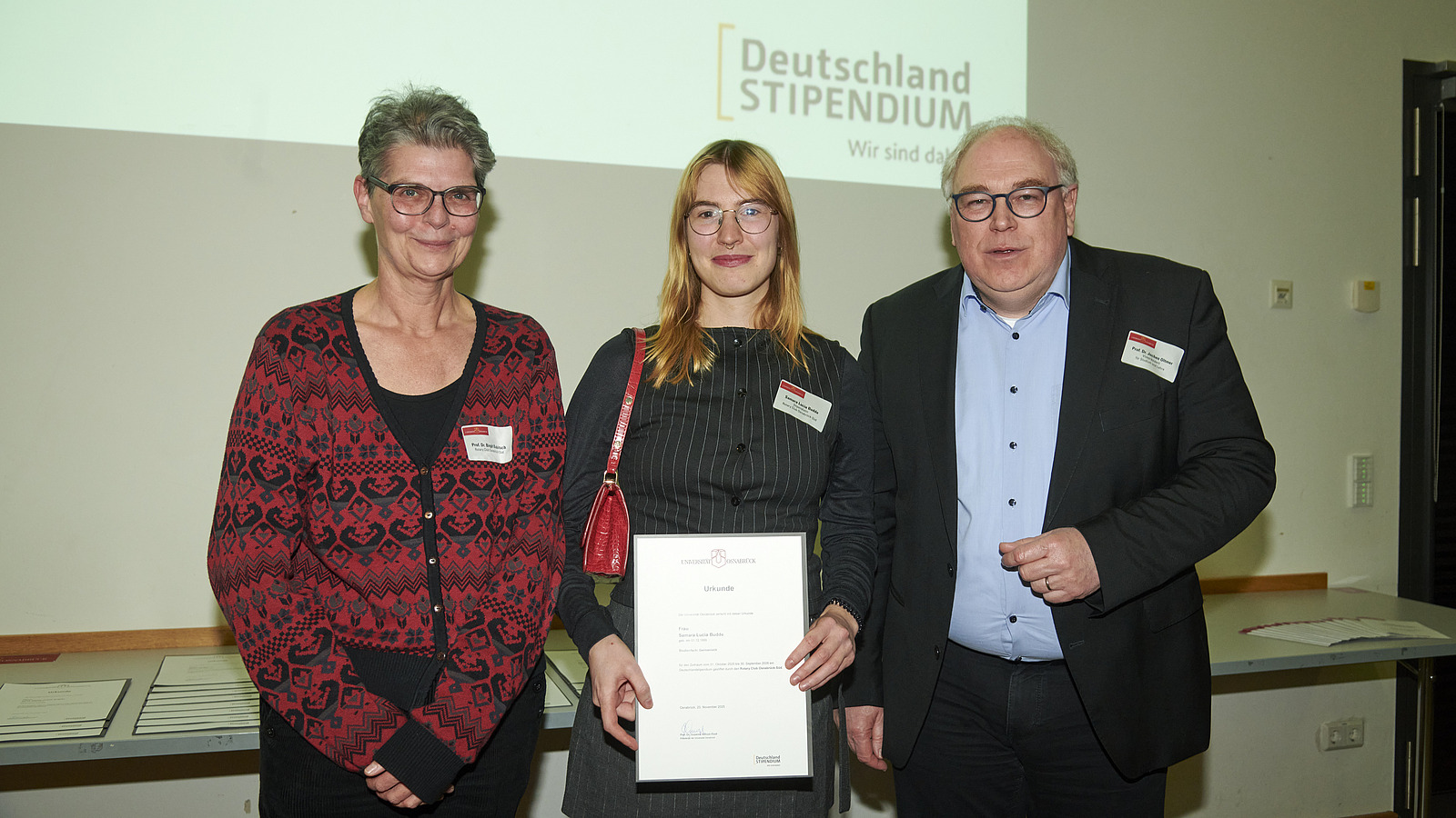 Mehrere Personen auf Bühne bei Urkundenübergabe