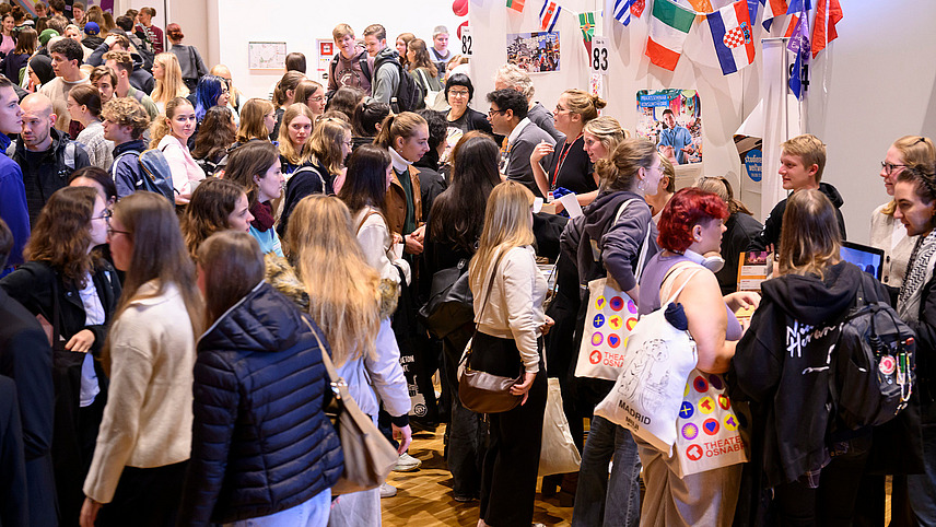 View of colorful booths with numerous people gathering information