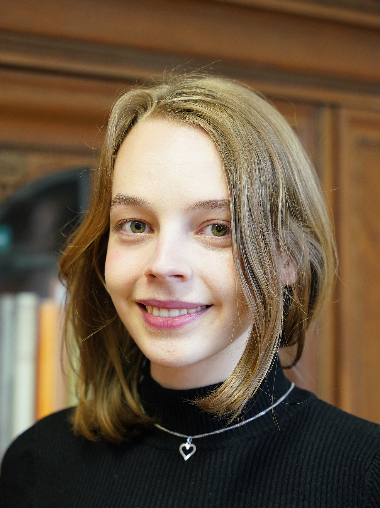 Theresa Heeren, studentische Hilfskraft. Sie hat schulterlange, dunkelblonde Haare. Sie trägt eine schwarze Bluse.
