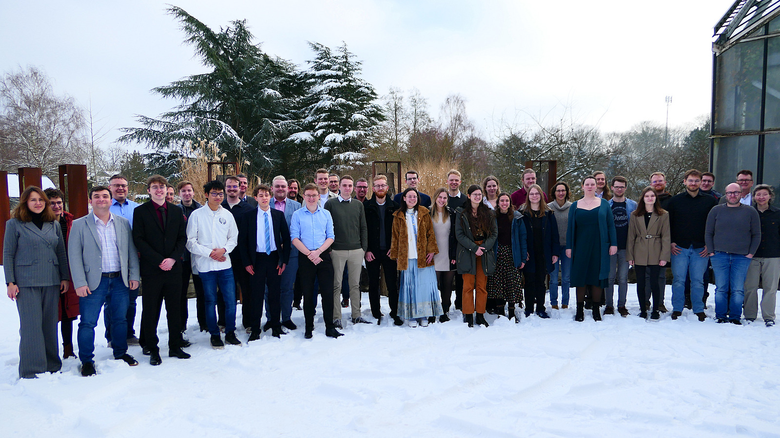 Viele Personen haben sich im Schnee f&uuml;r ein Gruppenfoto aufgestellt.