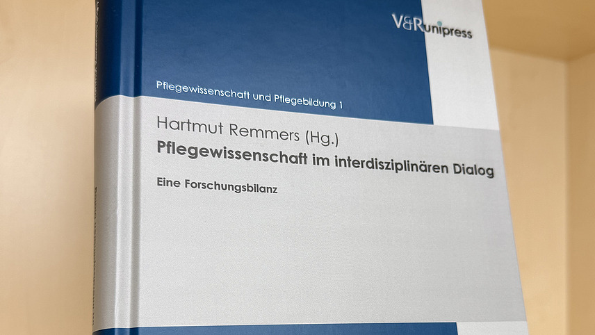 Ein Fachbuch von Hartmut Remmers mit dem Titel "Pflegewissenschaft im interdisziplin&auml;ren Dialog" steht in einem Regal.