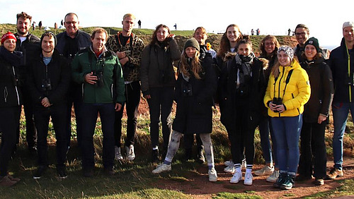 Excursion participants stand on the coast of Heligoland and smile for the camera.