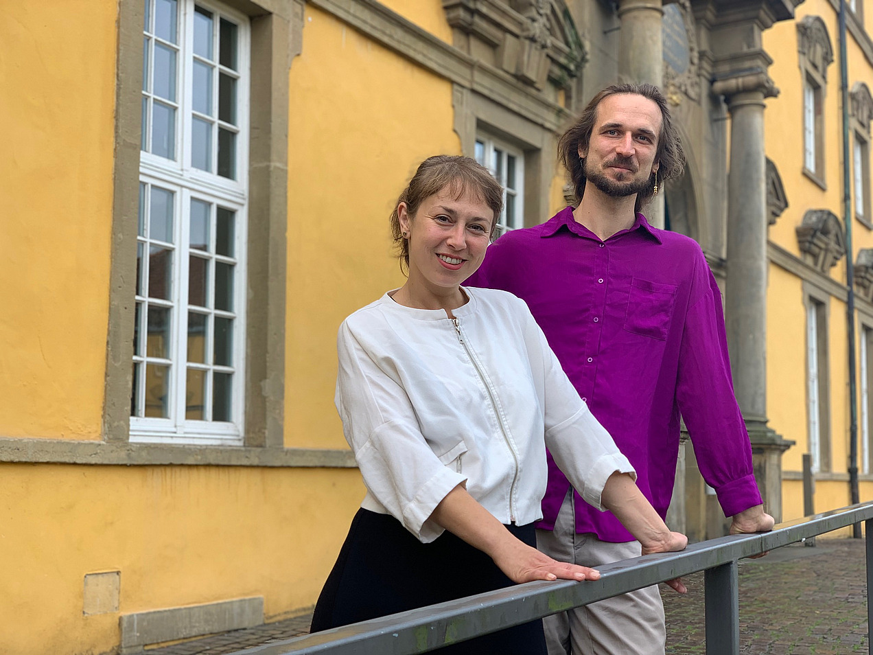 Eine Frau und ein Mann stehen vor dem Osnabrücker Schloss. 
