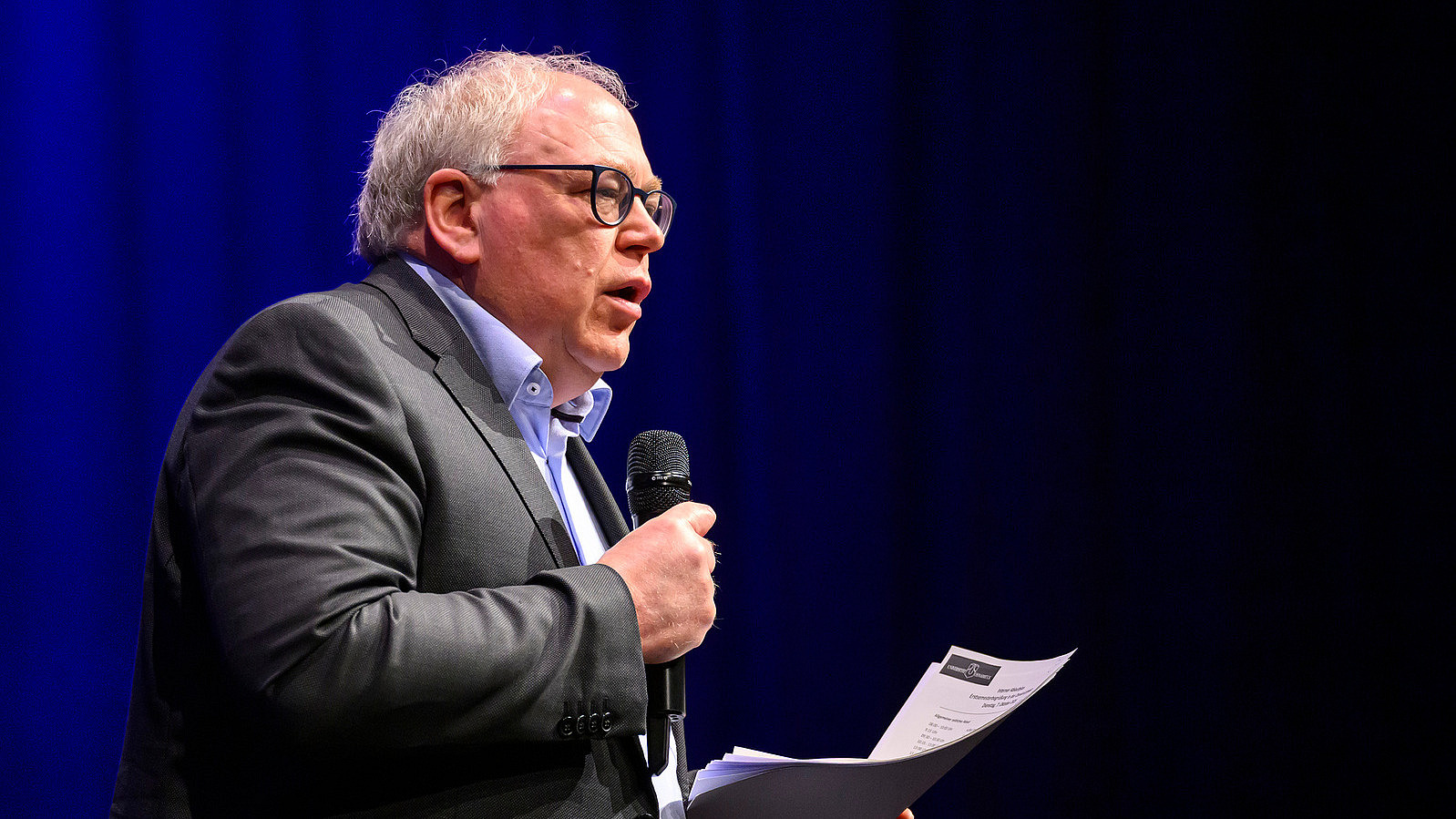 Close-up of Prof. Jochen Oltmer, Vice President for Academic Affairs. He is speaking into a microphone and looking toward the audience.