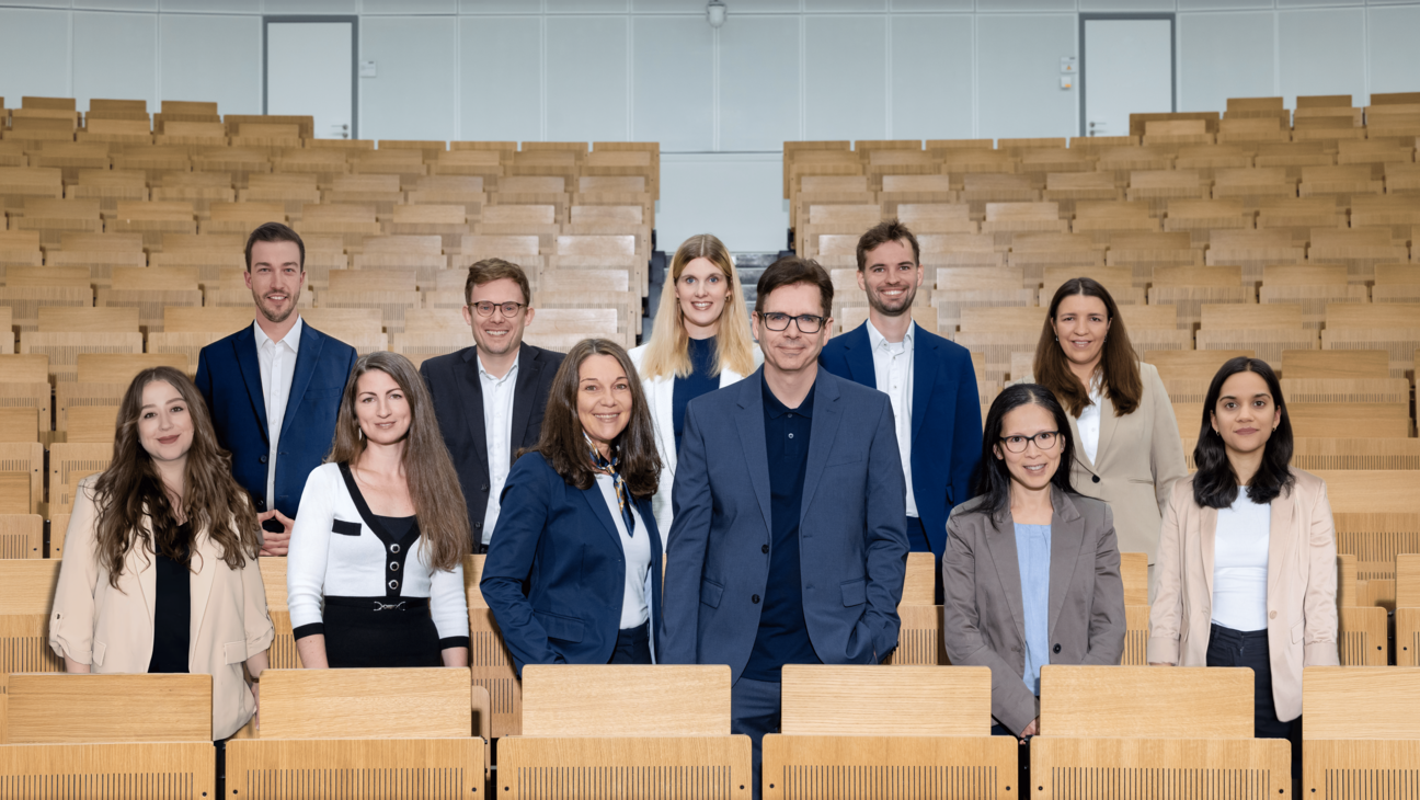 UWI Team steht im Vorlesungssaal