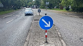 Ein Auto fährt an einer Verkehrsinsel vorbei