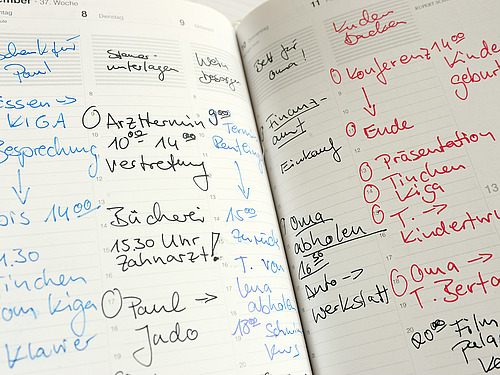 A daily planner lies open showing both work appointments and appointments with the family