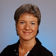Frau lächelt vor blauem Hintergund.
