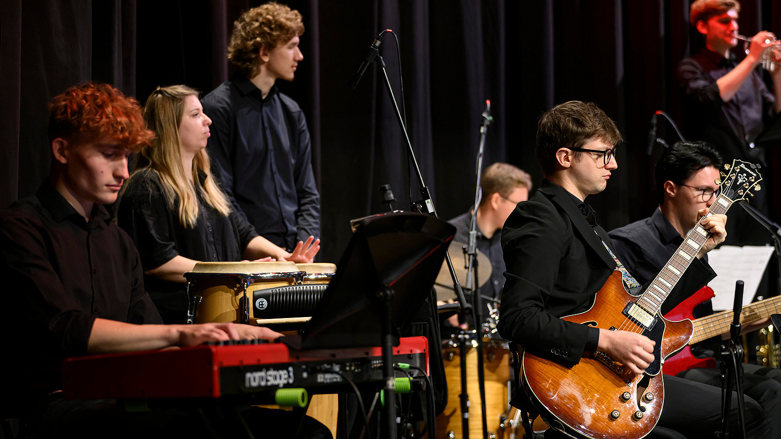 Close-up of several musicians playing different instruments