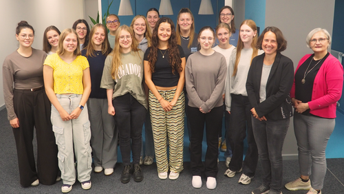 Eine Gruppe von Frauen posiert für ein Gruppenfoto in einem Büro. 