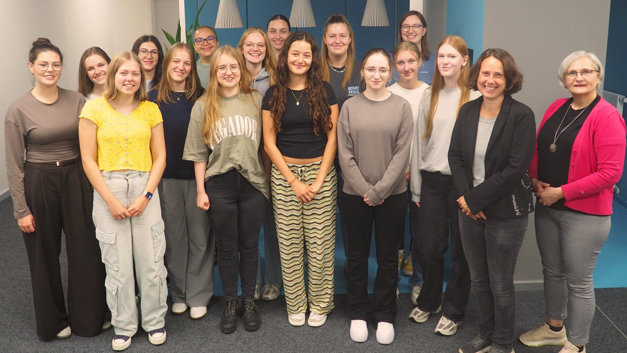 Eine Gruppe von Frauen posiert für ein Gruppenfoto in einem Büro. 