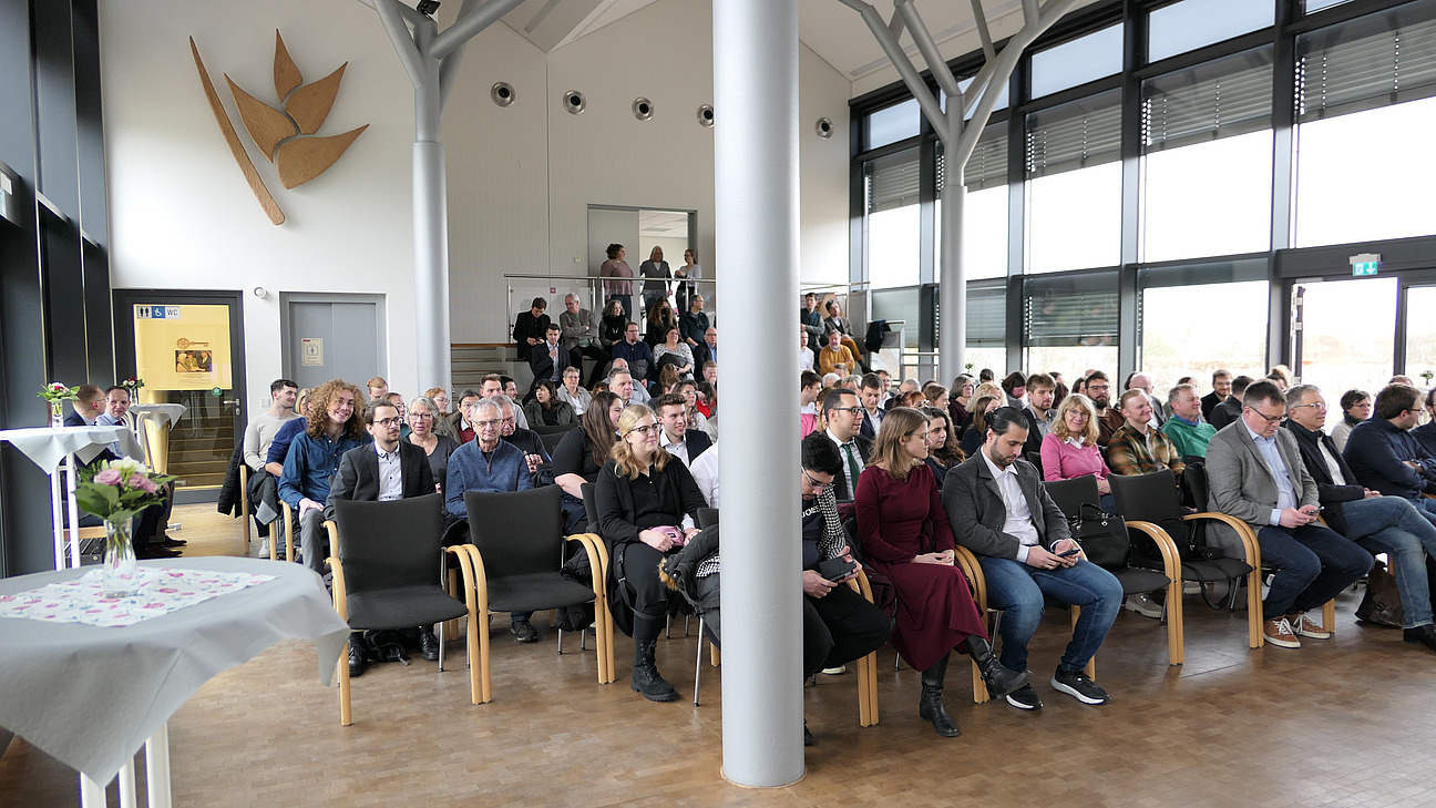 Graduates sit with their parents in the Helikoniensaal of the Botanical Garden.