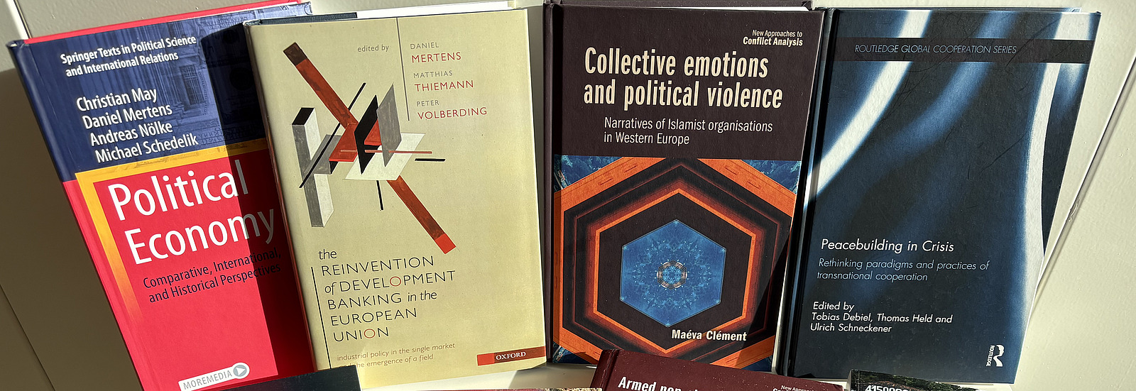 B&uuml;cher von Autor:innen des Center for the Study of Conflict and Peace ausgebreitet auf einem Tisch