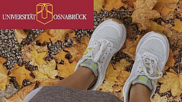mit Turnschuhen bekleidet auf Herbstlaub stehend