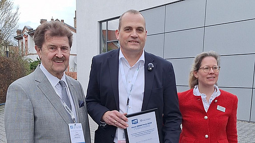 Two men and a woman look into the camera.