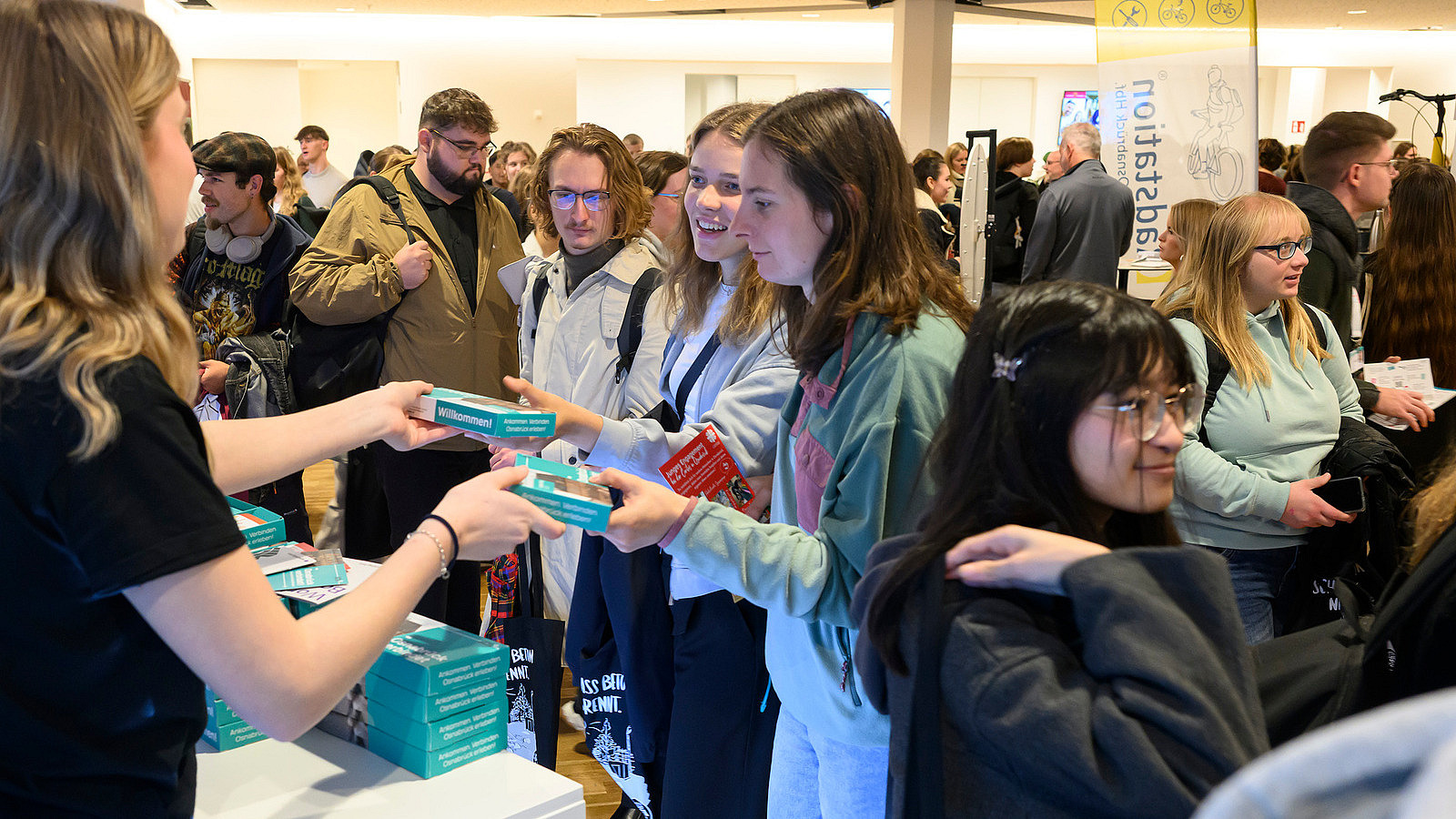 Several people at an information booth are given a giveaway