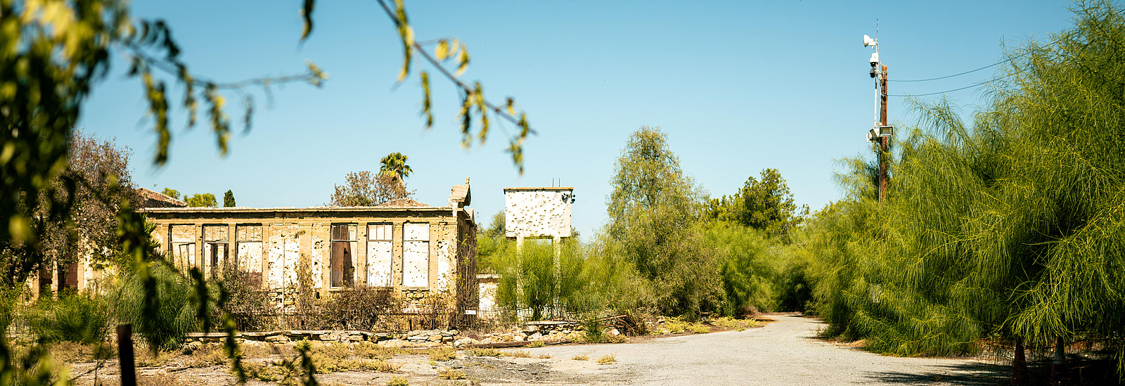 Photograph of the UN buffer zone in Cyprus: two buildings with bullet holes, blue sky above.