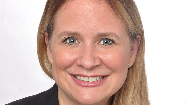 a woman with blonde long hair is smiling into the camera