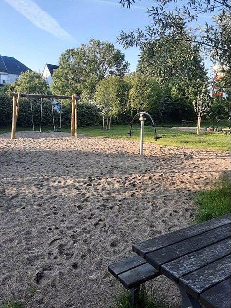 Spielplatz mit Schaukeln, Wippe und Tisch aus Holz