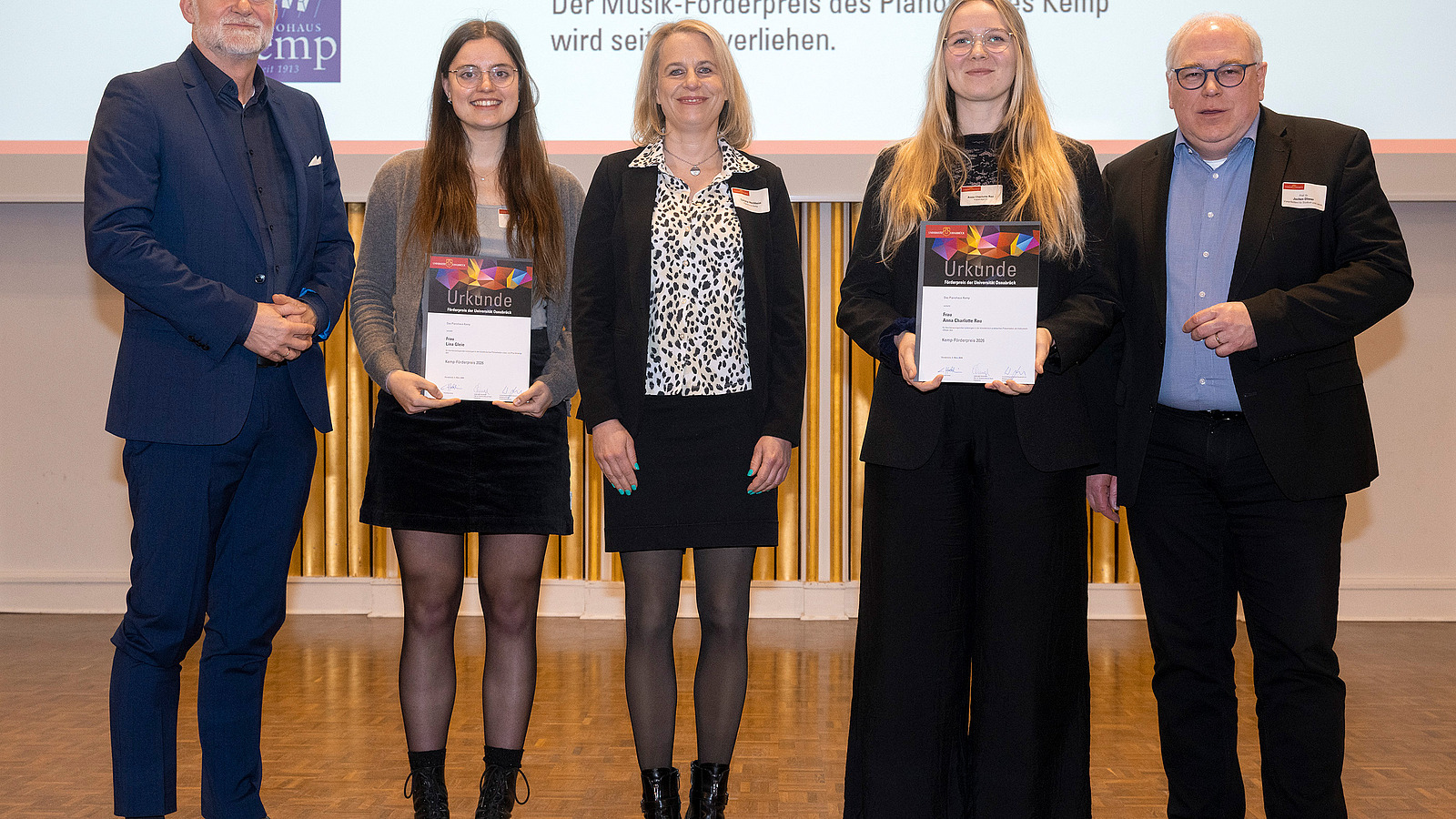 Award winners, sponsors, and the vice president stand together on stage and smile at the camera