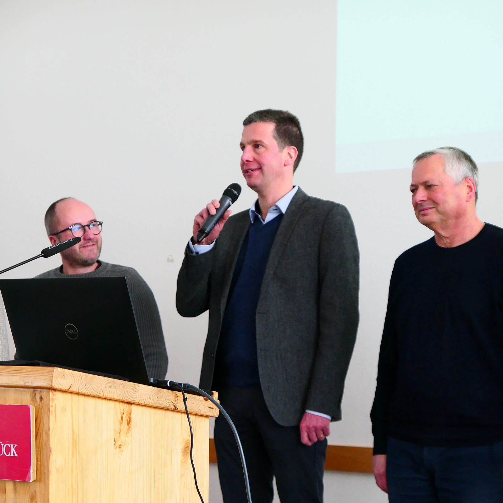 Ein Dozent h&auml;lt ein Mikrofon in der Hand.