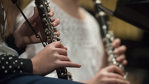 Two musicians play clarinets. 