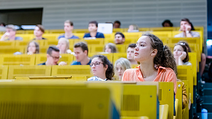 View of students across the rows of seats in a lecture hall.