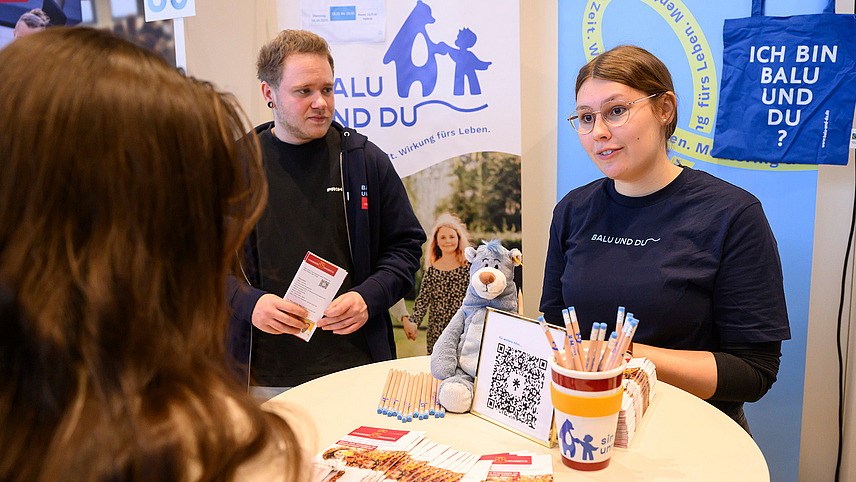 Several people at an information booth