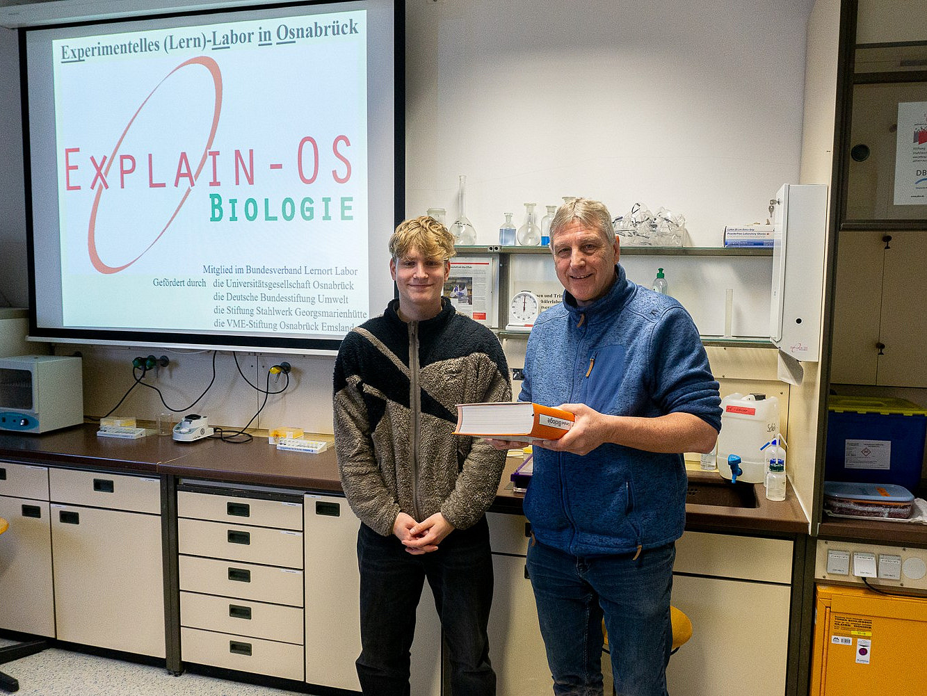 PD Dr Knut Jahreis presents the 15,000th student of the learning laboratory with a book as a gift.