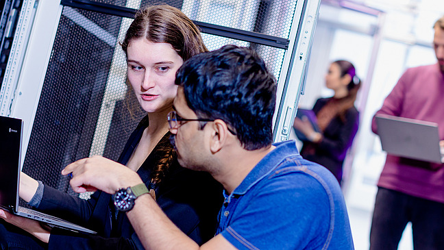 A working group of researchers discussing in the computer center.