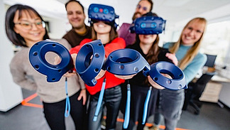 Eine Gruppe von jungen Menschen h&auml;lt Virtual-Reality-Brillen in die Kamera