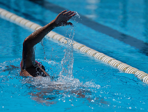 Ein Mensch krault im Schwimmbad
