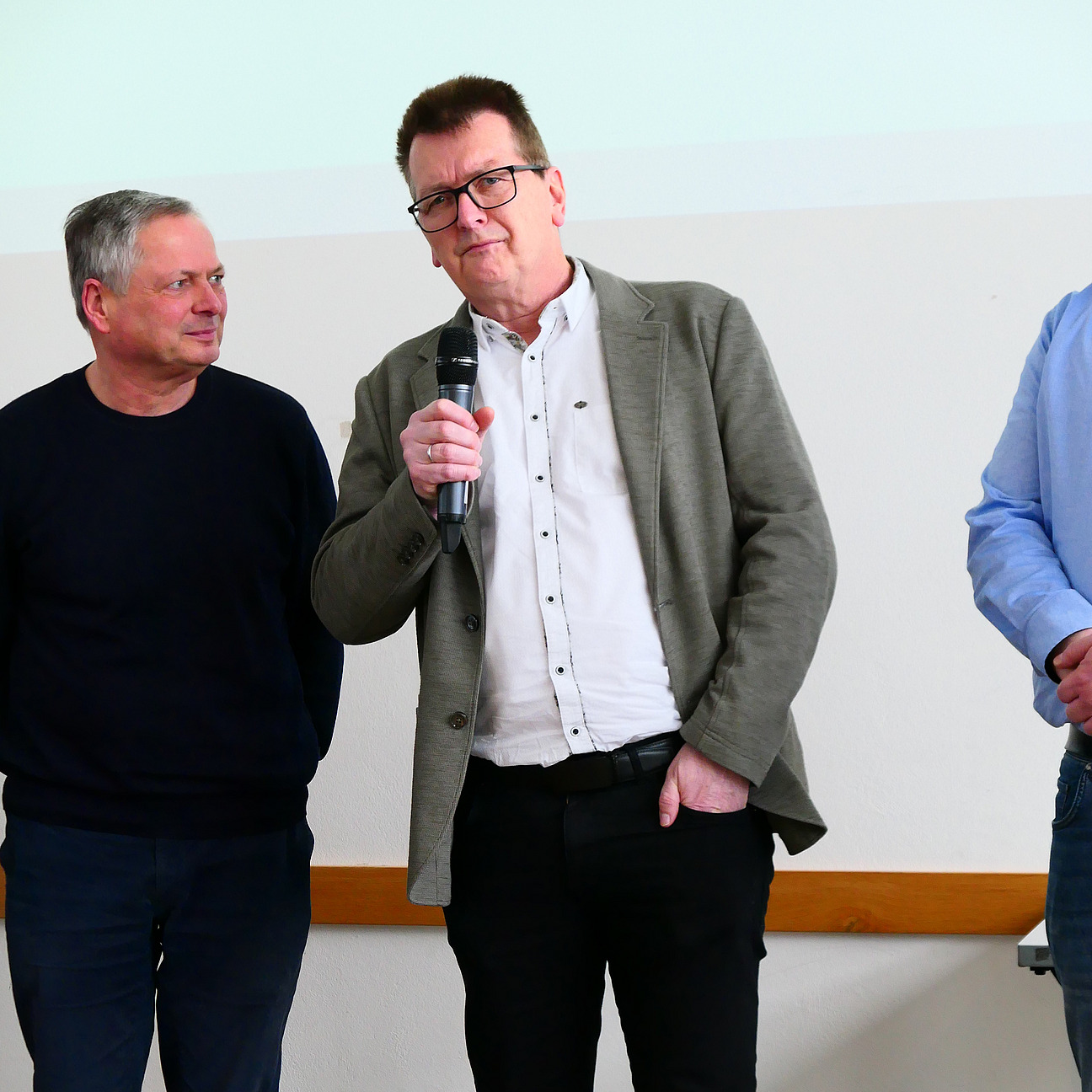 Ein Dozent h&auml;lt ein Mikrofon in der Hand.