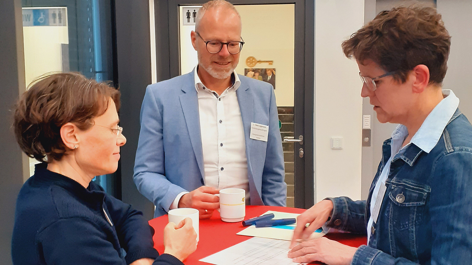 Teilnehmende am Tisch beim Gespr&auml;ch