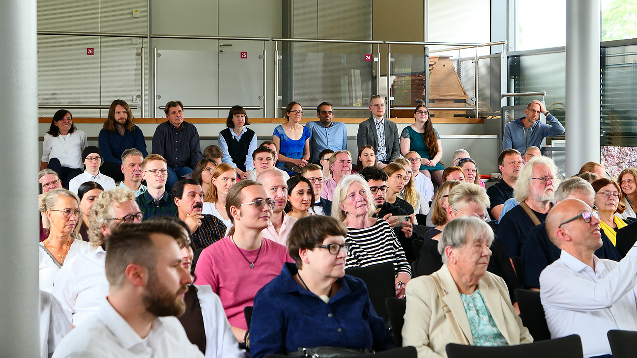 Viele Personen sitzen in einem Vortragsraum.