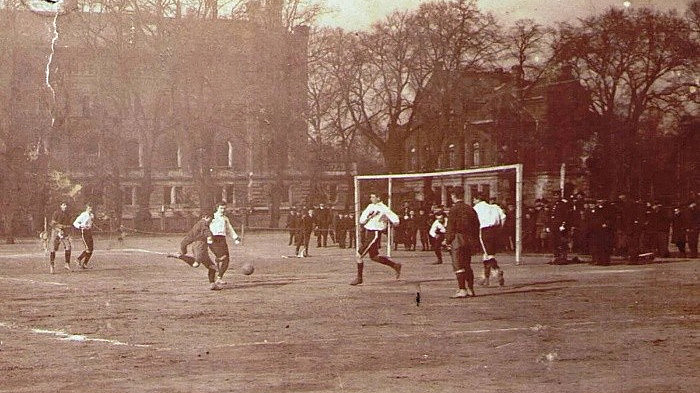 R&ouml;tlich get&ouml;nte Fotografie vom einem Fu&szlig;ballspiel 