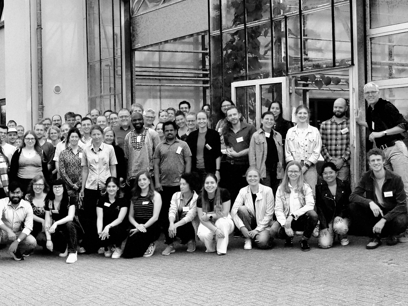 A black-and-white photograph of a large group of people smiling at the camera.