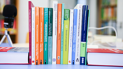 Mikrofon und Bücher liegen auf einem Tisch.