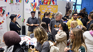 View of colorful booths with numerous people gathering information