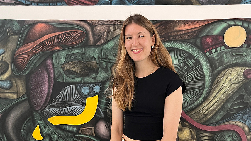 Eine junge Frau l&auml;chelt in die Kamera.