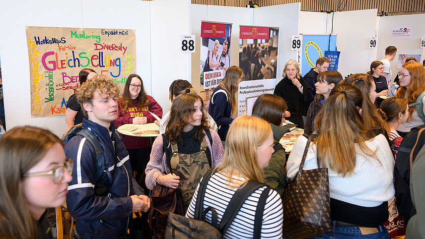 View of colorful exhibition stands with numerous people gathering information
