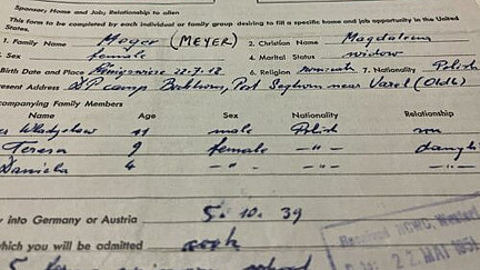 Ein Formular enthält handschriftliche Einträge mit Informationen zu einer Familie, darunter Namen wie "Meyer" und "Magdalena", sowie Geburtsdaten und Adressen. Details wie "DP Camp" und "Baldwin" sind erkennbar. Es umfasst auch Angaben über begleitende Familienmitglieder, deren Alter, Geschlecht und Nationalität. Auf dem Formular sind Stempel sichtbar