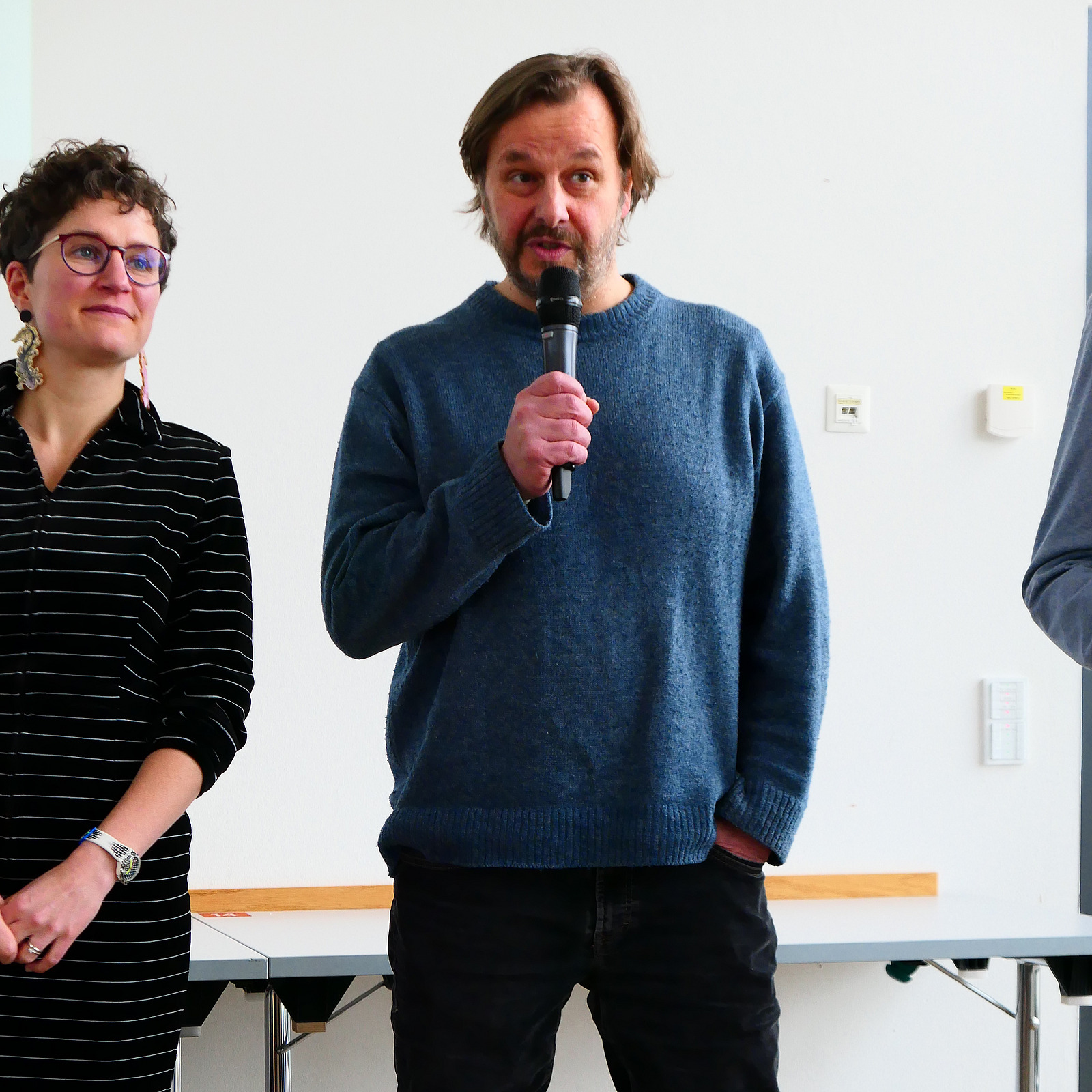 Ein Dozent h&auml;lt ein Mikrofon in der Hand.